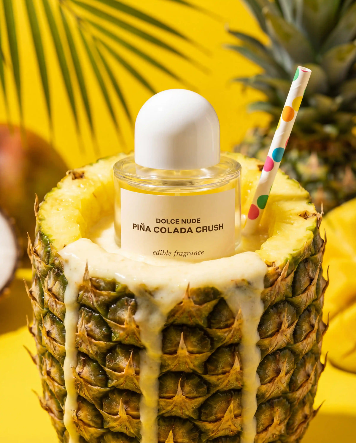 Piña Colada Crush edible perfume by DOLCE NUDE in a tropical poolside setting with pineapples and coconut cream